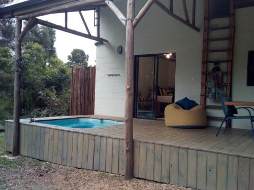 una casa con piscina en una terraza de madera en Plettenberg Bay Cottage, en Plettenberg Bay