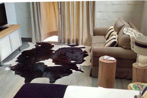 sala de estar con alfombra blanca y negra en el suelo en Plettenberg Bay Cottage, en Plettenberg Bay
