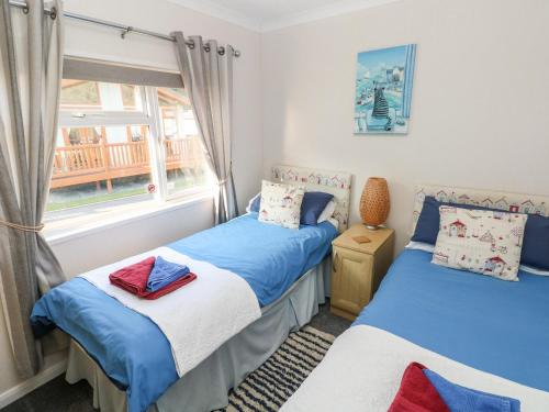 two beds in a room with a window at Tranquillity - Heritage Park in Narberth