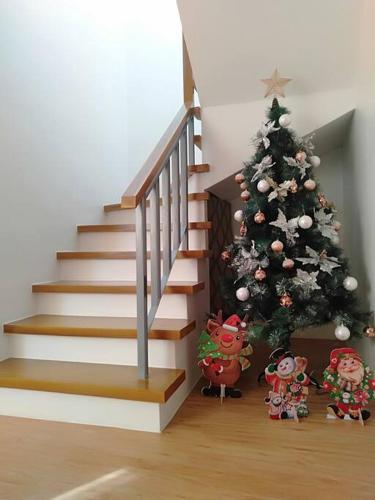 a christmas tree in a room with a staircase at Avida 3-Bedroom Vacation House with Pool in Minuluang