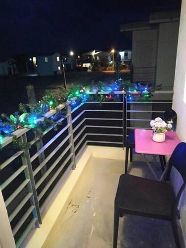 a balcony with a table and lights on a fence at Avida 3-Bedroom Vacation House with Pool in Minuluang