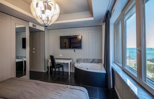 a bedroom with a bed and a tub and a desk at Partenope Relais in Naples