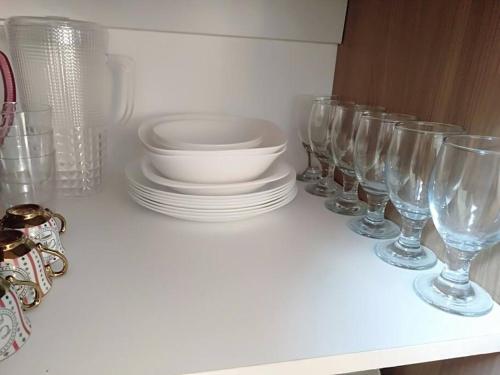 a row of wine glasses and plates on a shelf at Avida 3-Bedroom Vacation House with Pool in Minuluang