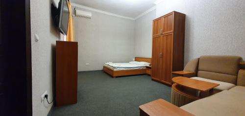 a small room with a bedroom with a bed and a chair at Apart-Hotel City Center Contrabas in Lviv