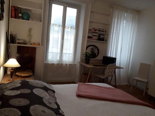 坎佩爾的住宿－"Authentique" - appart étage 1 - Loc'h finistère - N4，一间卧室配有一张床、一张书桌和一个窗户。