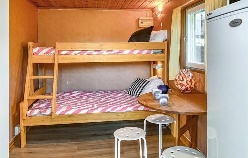 een kleine slaapkamer met een stapelbed en een tafel met stoelen bij Nannas Stuga in Visby