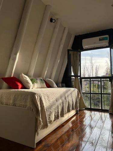 a bedroom with a bed and a large window at Chacras House in Ciudad Lujan de Cuyo