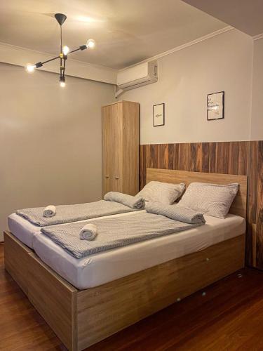 a bedroom with a large bed with a wooden headboard at Prenociste Lane in Ključ