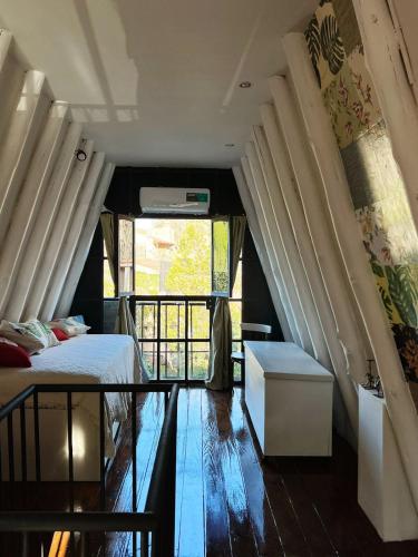 1 dormitorio con cama y ventana grande en Chacras House en Luján de Cuyo