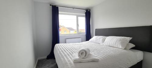 een bed met een handdoek en een raam bij Shanti in Darlington