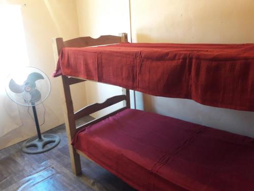 a room with two bunk beds with a fan and a chair at Macrigaluma Luna in Barra del Chuy