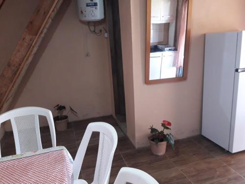 a dining room with white chairs and a table and a mirror at Macrigaluma Luna in Barra del Chuy