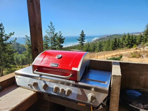 a red toaster sitting on top of a stove at Maravillosas Vistas Boyeruca Lodge in Vichuquén