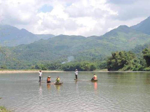 Homestay tuấn bảy في Yên Bái: مجموعة من الناس تقف في الماء على الزوارق