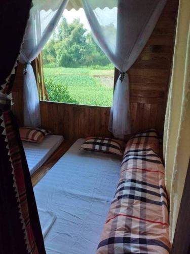 een kleine kamer met een bed en een raam bij Homestay tuấn bảy in Yên Bái