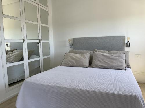 a bedroom with a white bed with a mirror at Recoleta Apartment in Buenos Aires