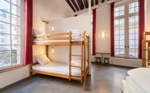 a bunk bed room with two bunk beds and two windows at MIJE MARAIS Hostel in Paris