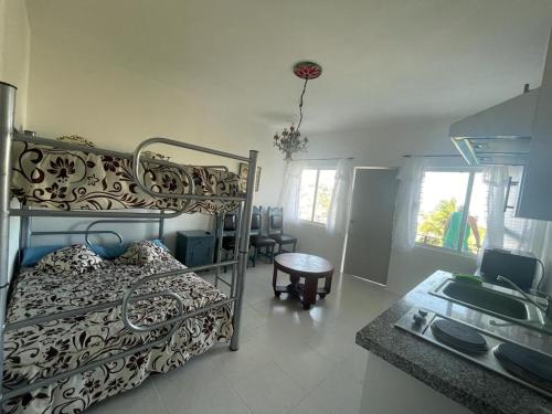 a bedroom with a bunk bed and a kitchen at Loft 208 in Acapulco