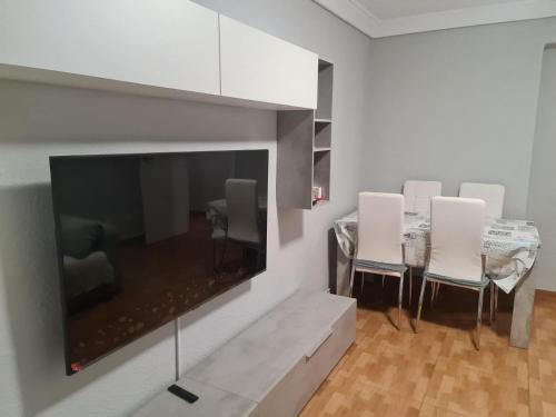 a dining room with a large tv and a table and chairs at Apartamento Zaragoza Plaza Europa in Zaragoza