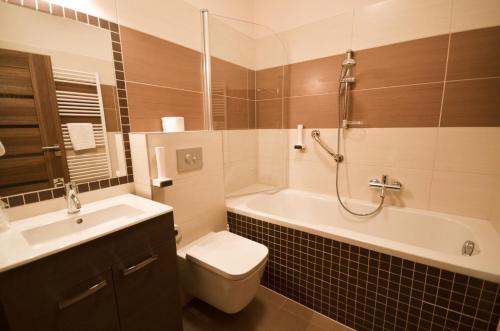 a bathroom with a tub and a toilet and a sink at Hotel U Kozicky in Teplice