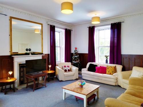a living room filled with furniture and a christmas tree at Pentland Farm House in Kirknewton