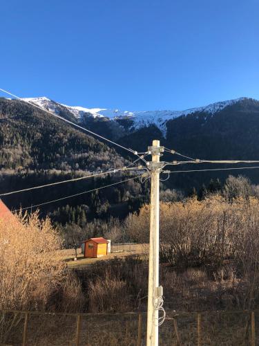 a telephone pole with a red barn in a field at Mountain House in Rigolato