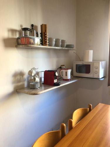 a kitchen with a counter with a microwave and chairs at Mountain House in Rigolato