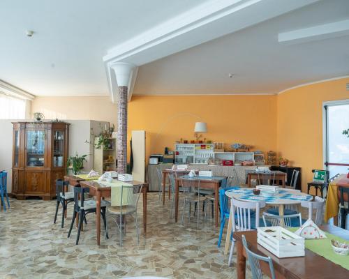 a dining room with tables and chairs and a kitchen at Hotel all'Oasi in Paese