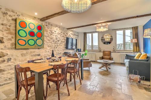 une salle à manger avec une table et des chaises et un salon dans l'établissement Appartement Garance, à Nîmes