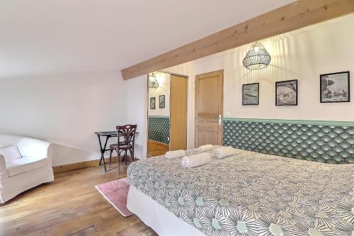 une chambre avec un grand lit et une table dans l'établissement Appartement Garance, à Nîmes
