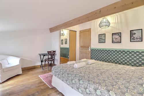 a bedroom with a large bed and a table at Appartement Garance in Nîmes