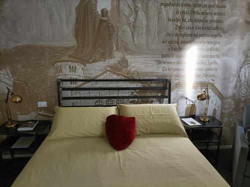 a bedroom with a bed with a red pillow on it at BB LETTERARIO in Ravenna