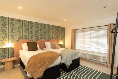 1 dormitorio con 2 camas y ventana en Flamingo Retreat, en Leicester