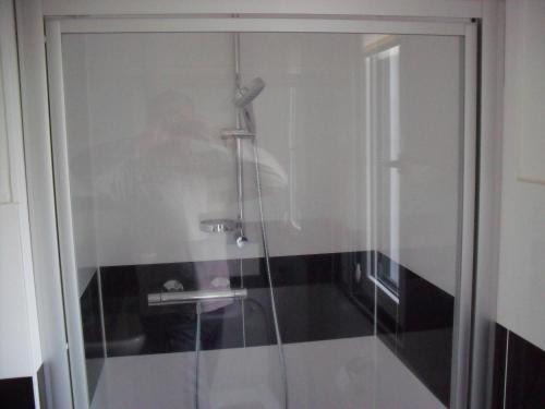 a glass shower door with a sink in a bathroom at Apartment Suda in Rheinhausen