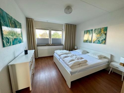 ein Schlafzimmer mit einem weißen Bett und einem Fenster in der Unterkunft Duinerei appartement C001 in Callantsoog