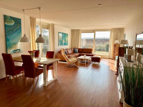 ein Wohnzimmer mit einem Tisch und einem Sofa in der Unterkunft Duinerei appartement C001 in Callantsoog