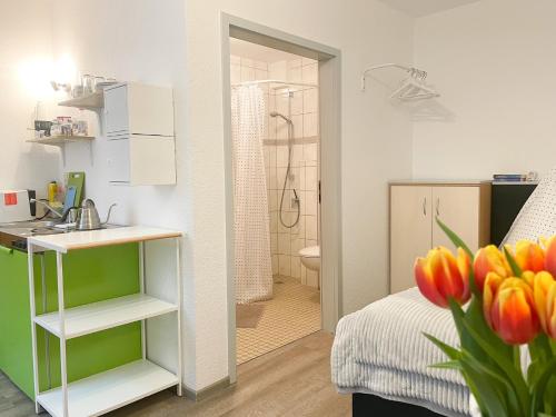 een slaapkamer met een bed, een wastafel en een badkamer bij Ferienzimmer Adalonia in Greifswald