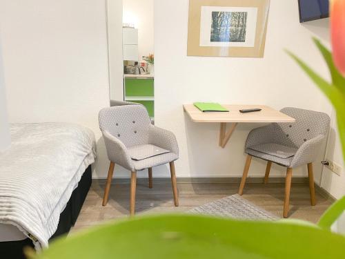 グライフスヴァルトにあるFerienzimmer Adaloniaのベッド、テーブル、椅子が備わる客室です。