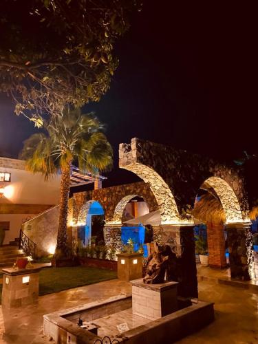 a stone building with a palm tree and a fountain at Casa Miura Hotel Boutique in Ajijic