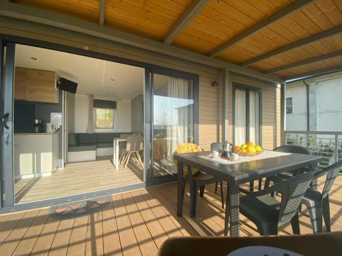 a screened in porch with a table and a kitchen at Agricamping Al grappolo diVino in Lazise