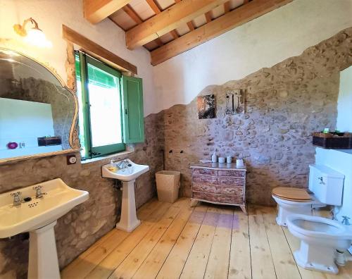 a bathroom with two sinks a toilet and a mirror at Vivalidays Casa Rural Anna Mieres Gerona in Mieres