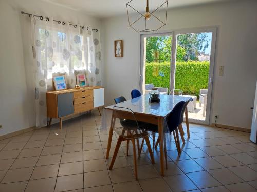 une salle à manger avec une table et des chaises et une fenêtre dans l'établissement Maison confort Trégomeur avec jardin et parking, à Trégomeur
