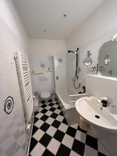 a bathroom with a black and white checkered floor at Schloss Rössing - Messezimmer in historischem Ambiente in Nordstemmen
