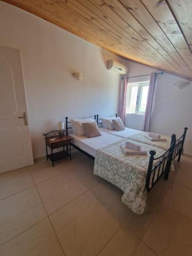 a bedroom with two beds and a window at Villa Mari in Makris Gialos