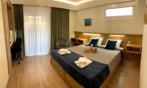 um quarto com 2 camas, uma secretária e uma janela em A&B Rhodes city apartments in Ilha de Rhodes