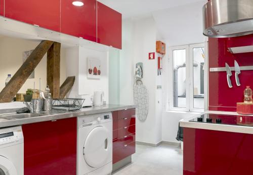 uma cozinha com armários vermelhos e uma máquina de lavar roupa em 262 Baixa Guesthouse em Lisboa