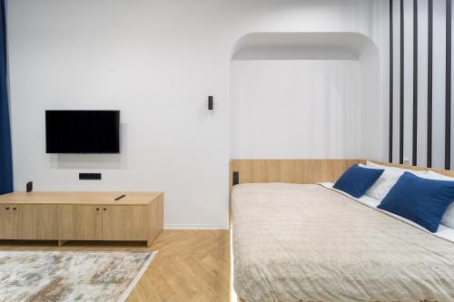 1 dormitorio con 1 cama y TV en la pared en Main Square, en Leópolis