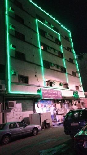 a building with green lights on the side of it at العييرى للشقق المخدومة الطائف in Taif