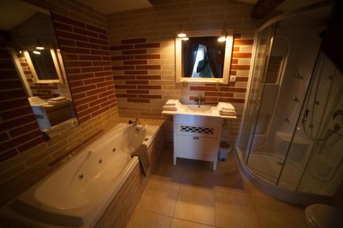 bagno con vasca, lavandino e doccia di Room in Guest room - Londres guest room in the heart of the vineyard a Badens
