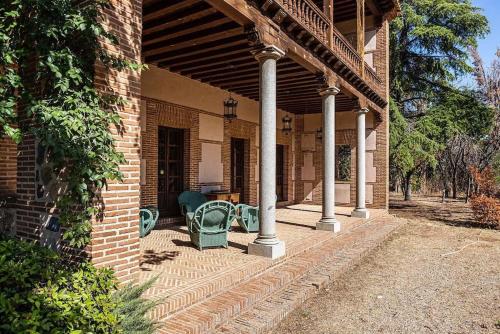 a porch of a brick house with chairs on it at Casa Palacio Toledo puy du fou in Toledo
